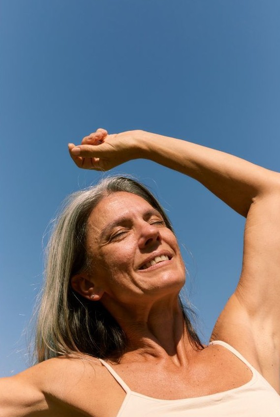 Mujer menopausia 50 años Mujer de 55 años sonriente disfrutando de bienestar en la menopausia